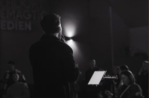 Man standing singing at church from the back